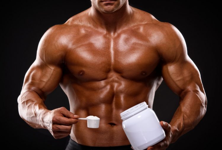 Άνδρας που παίρνει για συμπλήρωμα διατροφής κρεατίνη και χτίζει μύες