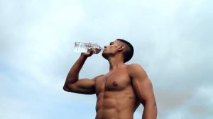 άντρας πίνει νερό μπουκάλι χτίσεις μύες