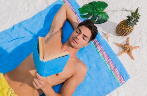 άντρας διαβάζει βιβλία παραλίας