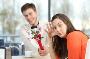 άντρας προσφέρει λουλούδια γυναίκα κοιτάει αλλού