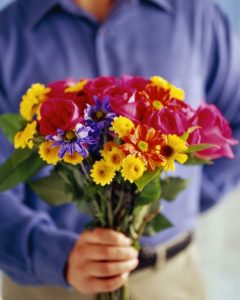 άντρας προσφέρει λουλούδια