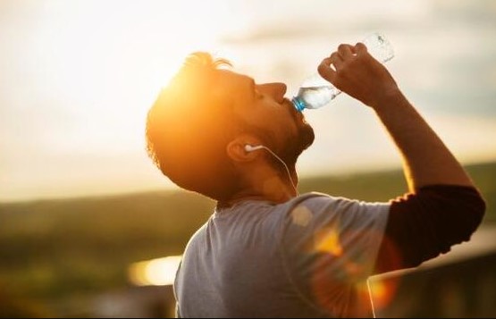 άντρας πίνει νερό σωσίβιο κοιλιάς