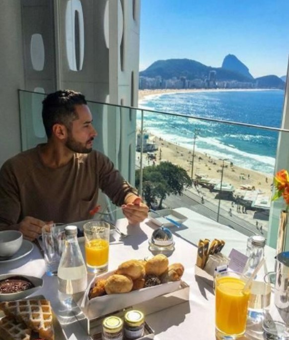 άντρας τρώει πρωινό σε ξενοδοχείο με θέα καλοκαιρινές διακοπές
